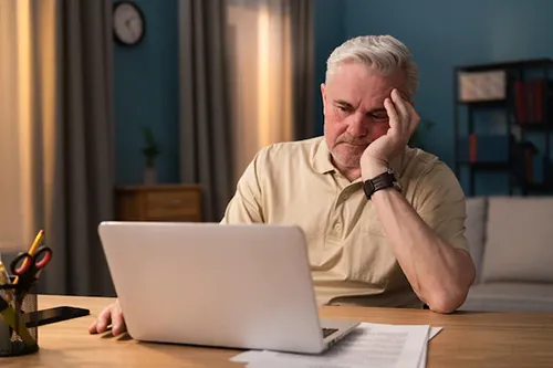 a frustrated man sitting at his computer