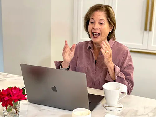 a woman excitedly telling her story in front of a computer